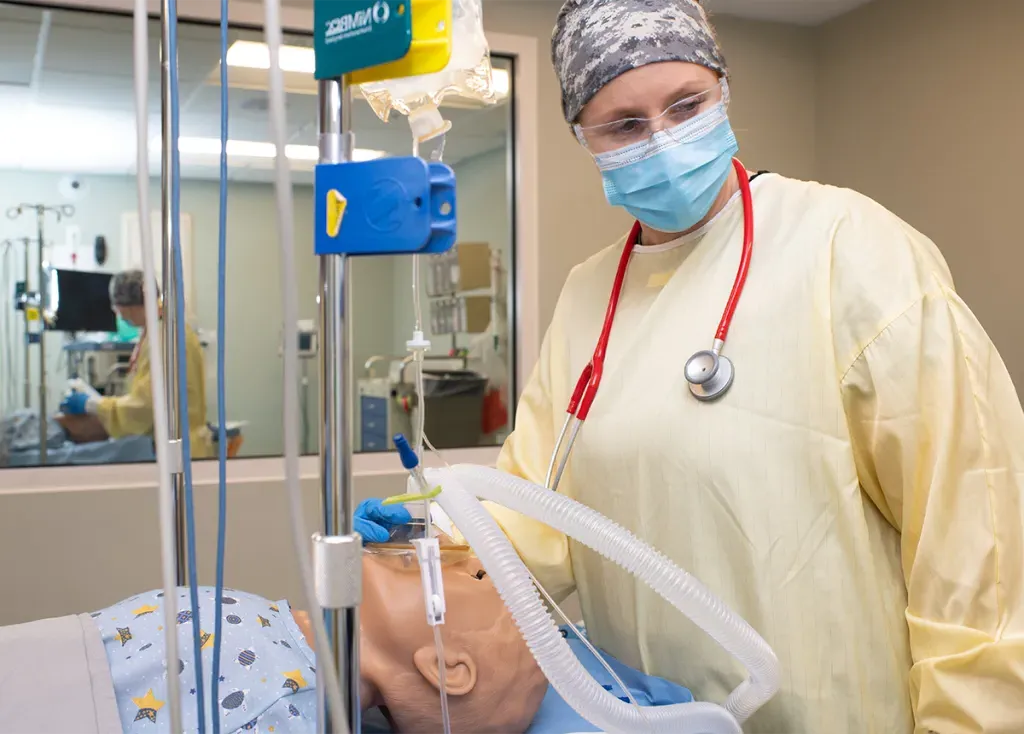 A nursing anesthesia student works on a patient simulator in the Sim Lab